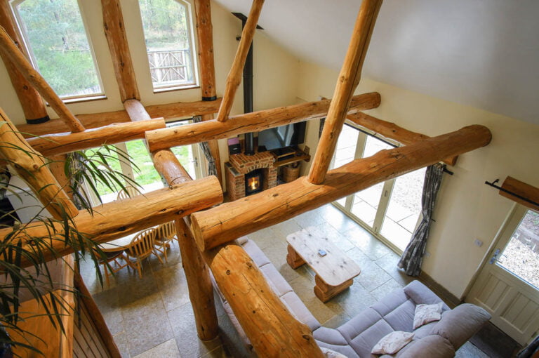 Loxleys Lodge is a hand built log cabin in the heart of sherwood forest. its interior features huge wooden beams cut from locally sourced timber. this is the view from the top of the stairs